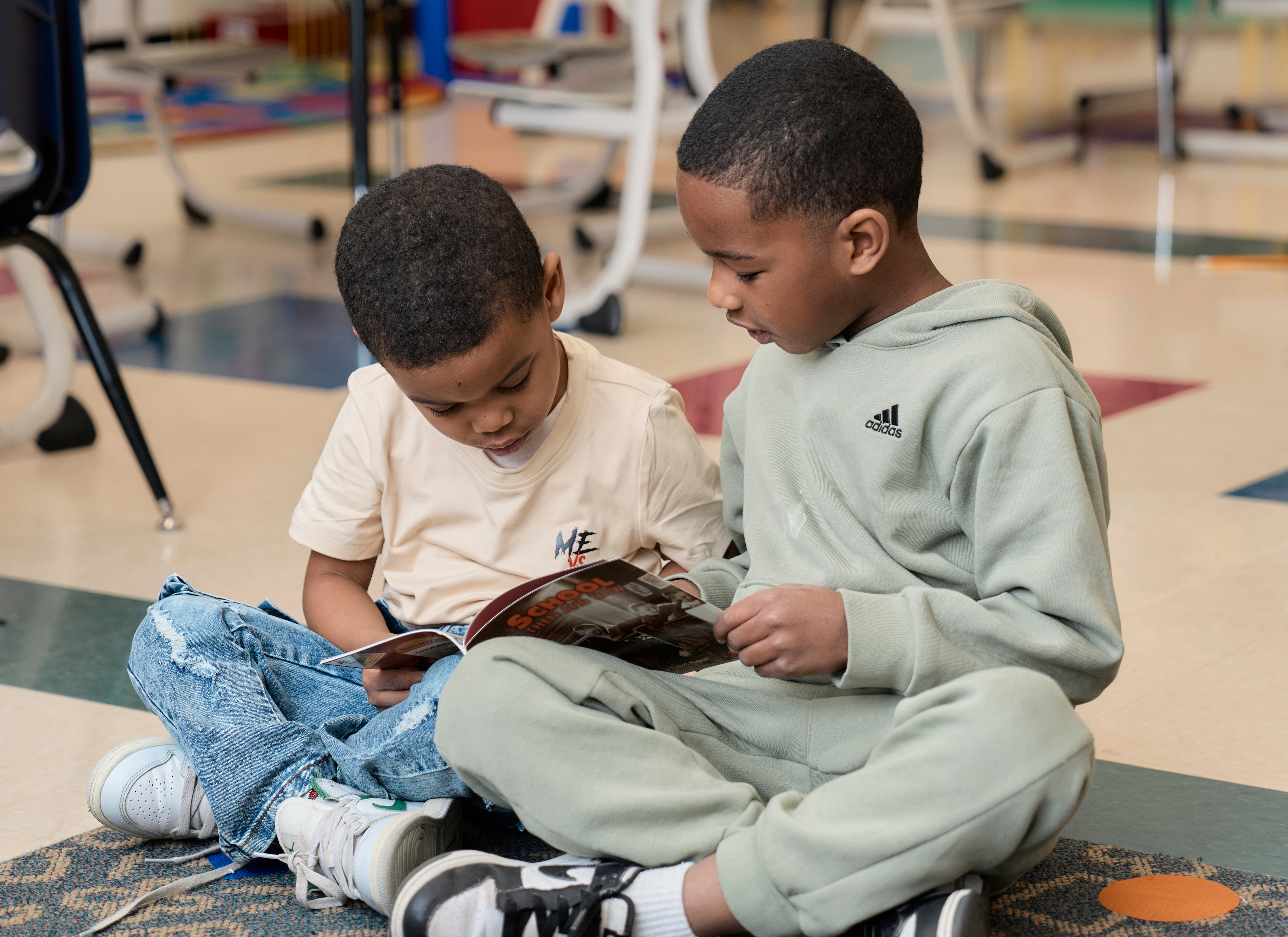 Two elementary boys reading books.
